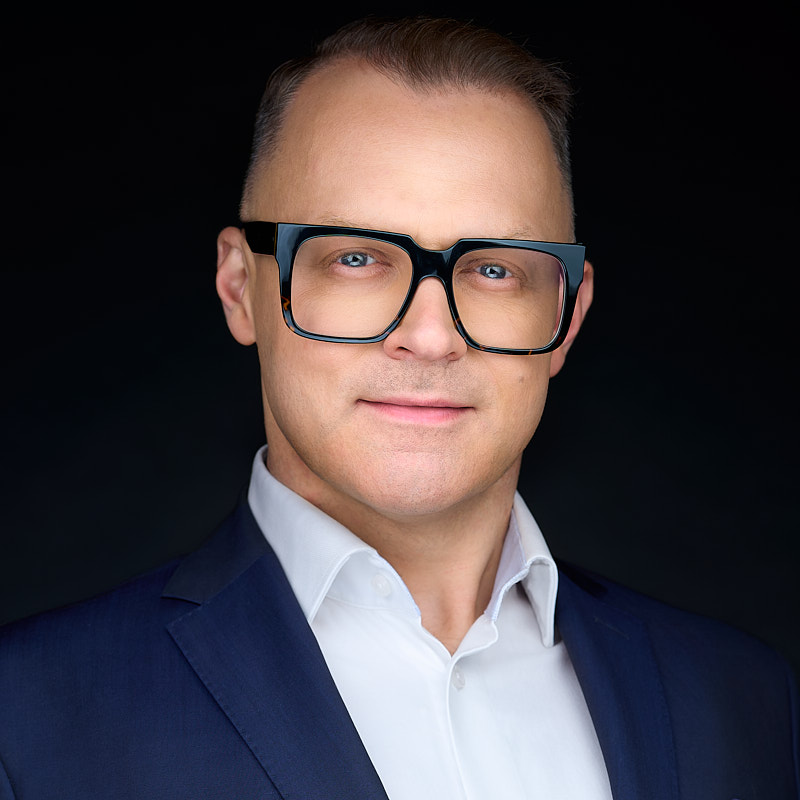 Headshot. Na zdjęciu lider biznesu. Zdjęcie na czarnym tle wykonane przez fotografa Marka Wołynko.
