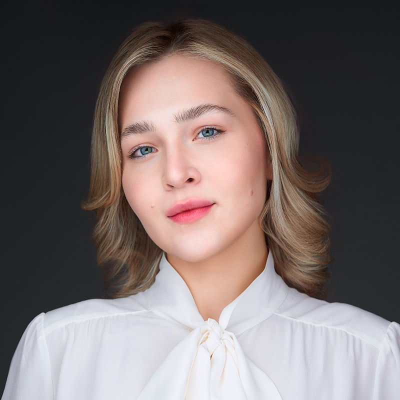 Najwyższej jakości portret headshot pracownicy Philips Polska. Zdjęcie na szarym tle wykonane przez Marek Wołynko podczas grupowej sesji biznesowej w siedzibie klienta.